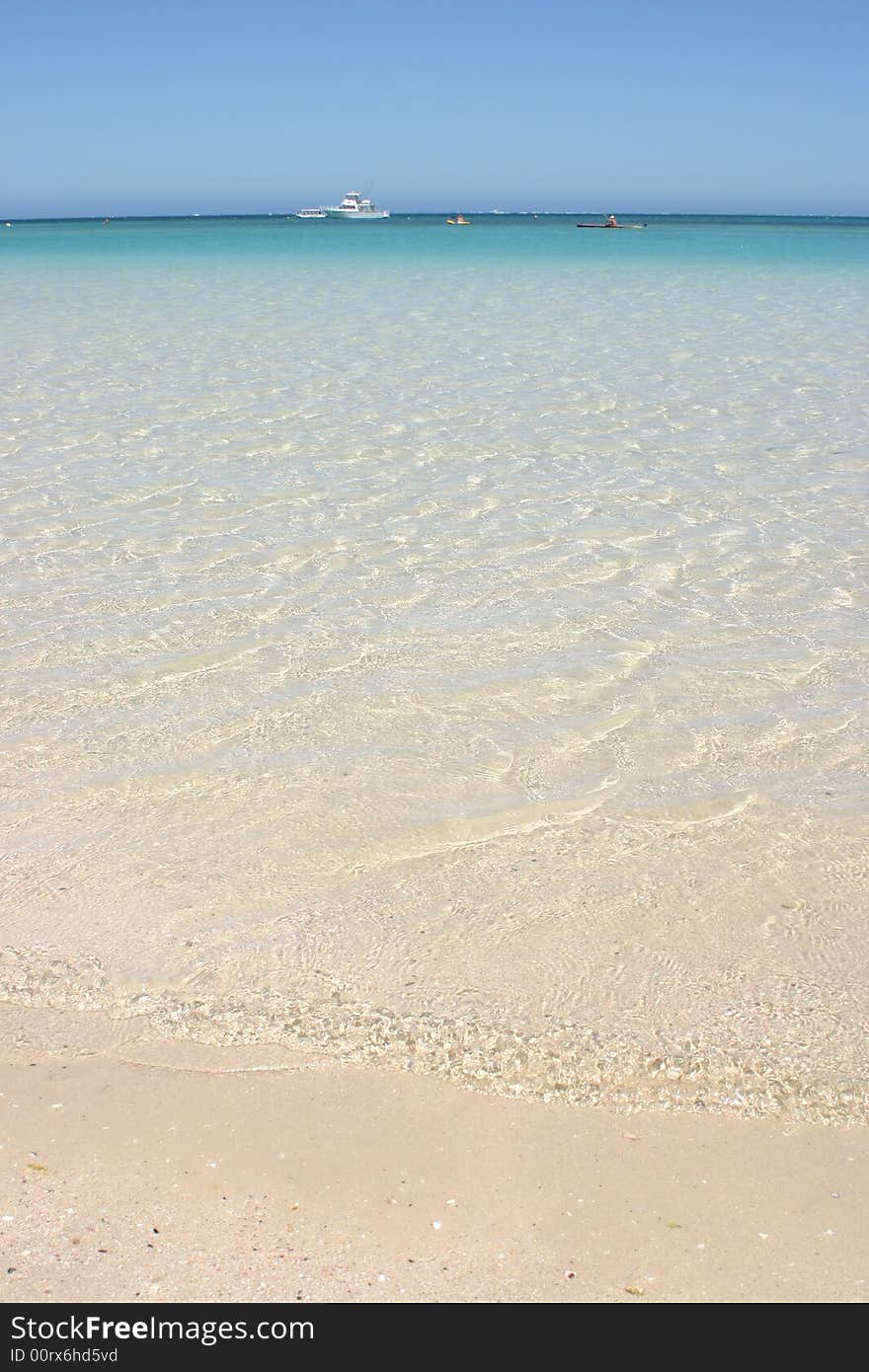 Beautiful turquoise clear ocean water with boat in background. Australia. Beautiful turquoise clear ocean water with boat in background. Australia.