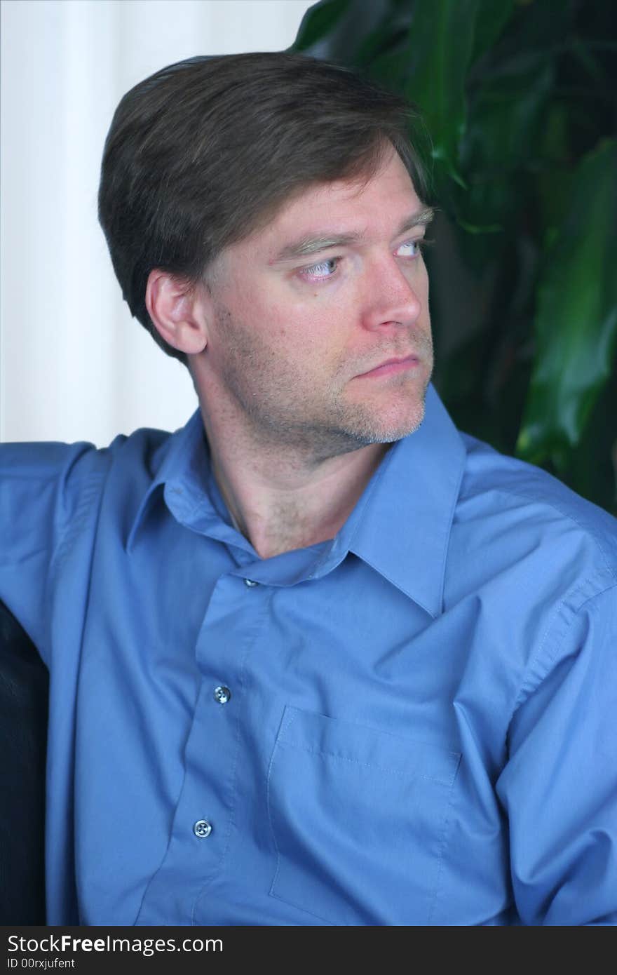 Handsome business man relaxing on couch, looking sideways