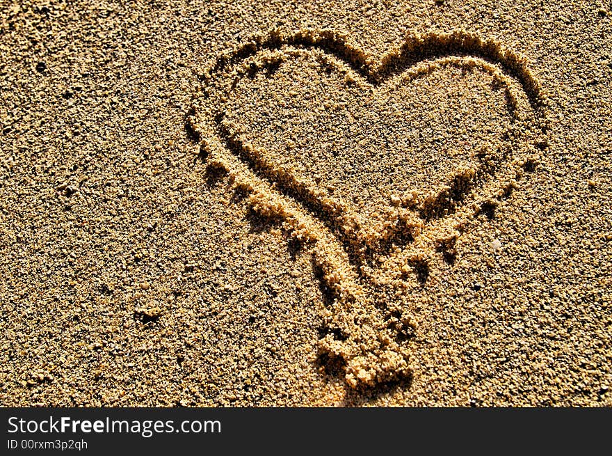 Heart shape symbol drawn in sand