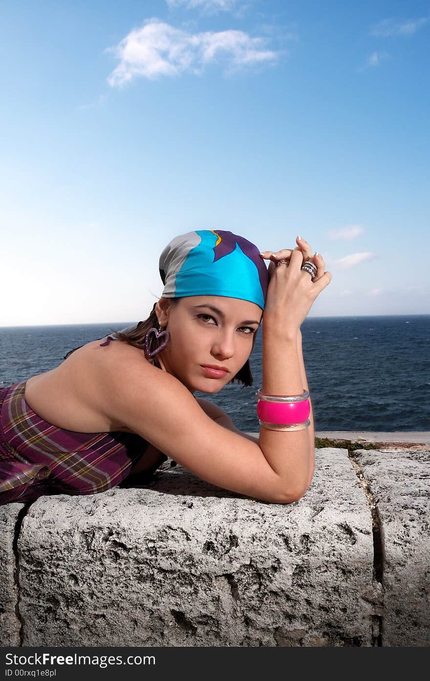 Portrait of young woman relaxing by the ocean. Portrait of young woman relaxing by the ocean