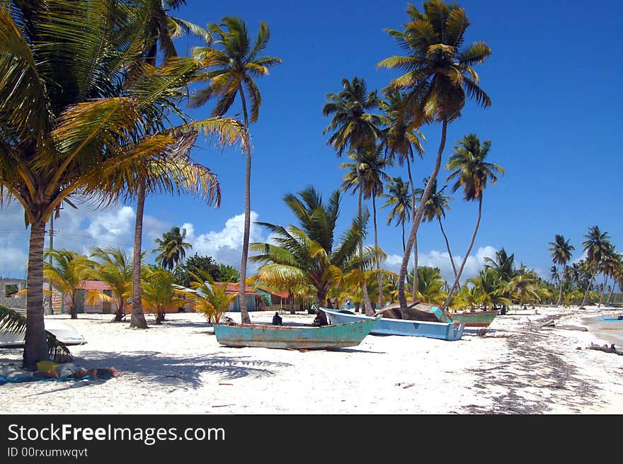 A tropical wild beach , with white sands and a coloured old boats of wooden. A tropical wild beach , with white sands and a coloured old boats of wooden