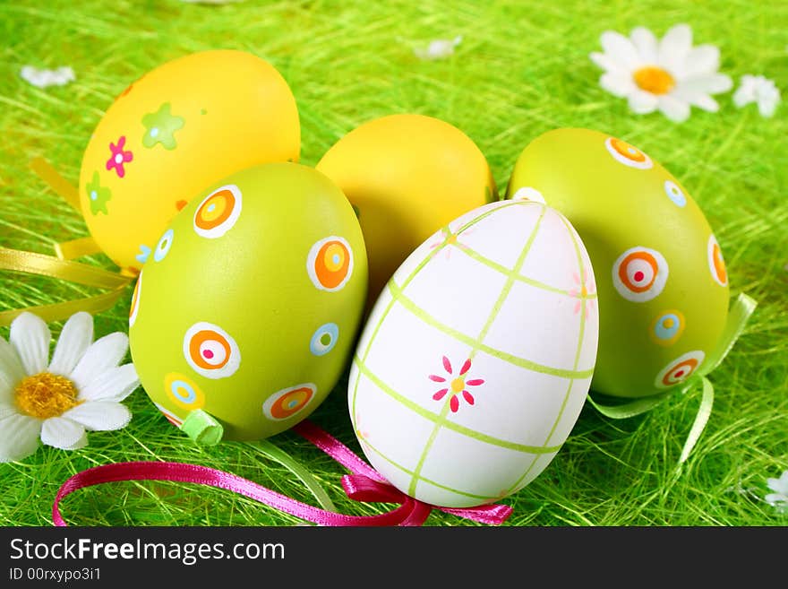 Pastel and colored Easter eggs on green