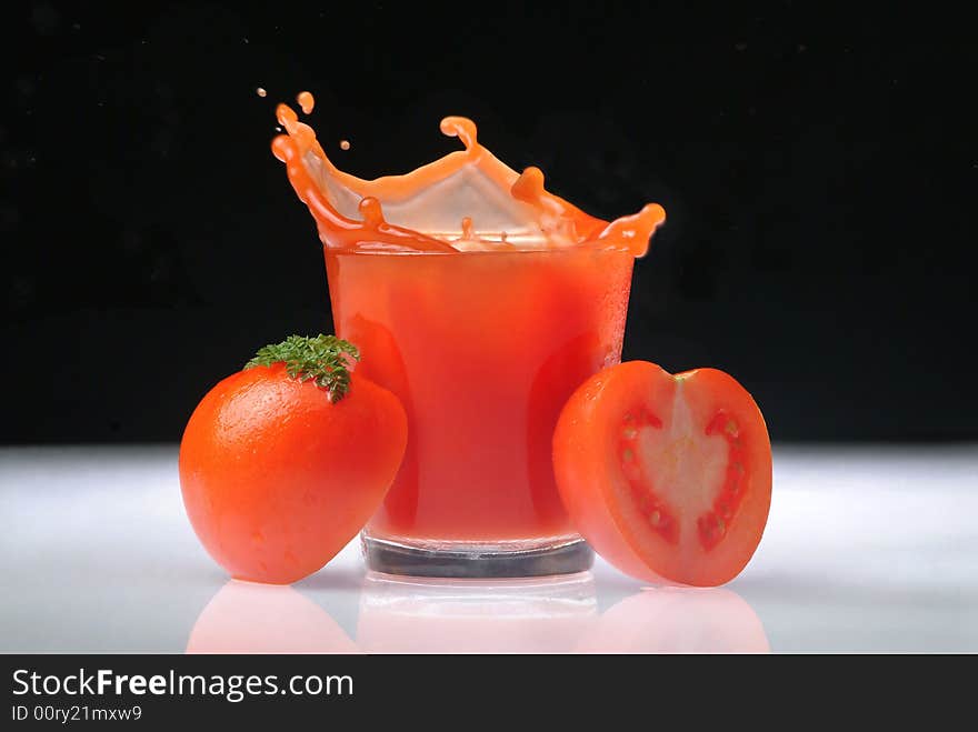 Spurting tomato juice with glass