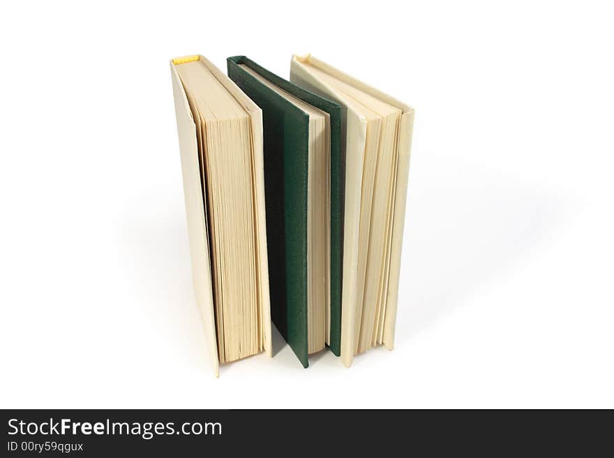 Three hardcover books standing on white background