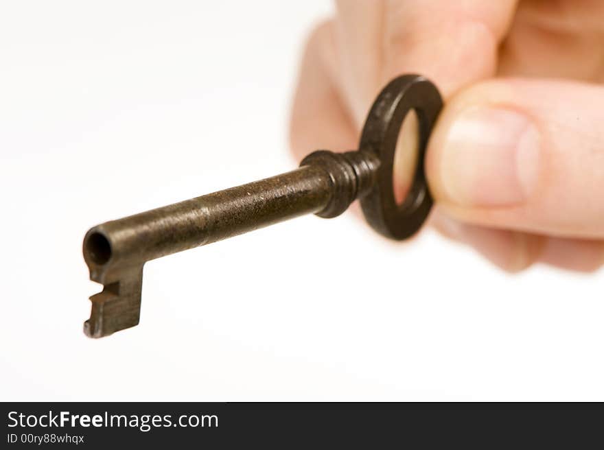 A hand holding an old key. Looks like it's about to open something.  Isolated on white background. A hand holding an old key. Looks like it's about to open something.  Isolated on white background.