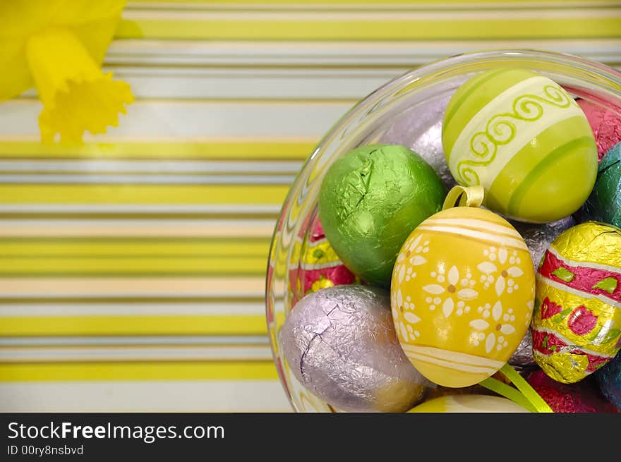 Easster eggs and yellow flower on a striped background. Easster eggs and yellow flower on a striped background.