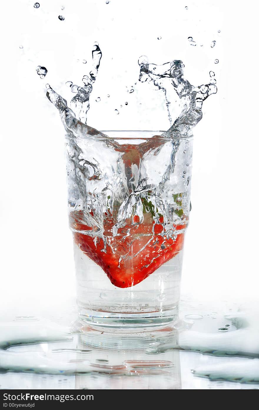 A strawberry making its splash into a glass of water. The water splash taking the shape of the strawberry from the way it enters the water. A strawberry making its splash into a glass of water. The water splash taking the shape of the strawberry from the way it enters the water.