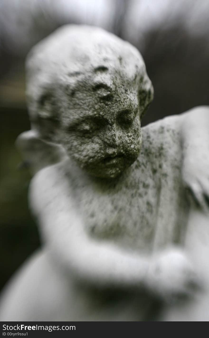 An old, deteriorating statue of an angel in a cemetery with special focus. An old, deteriorating statue of an angel in a cemetery with special focus