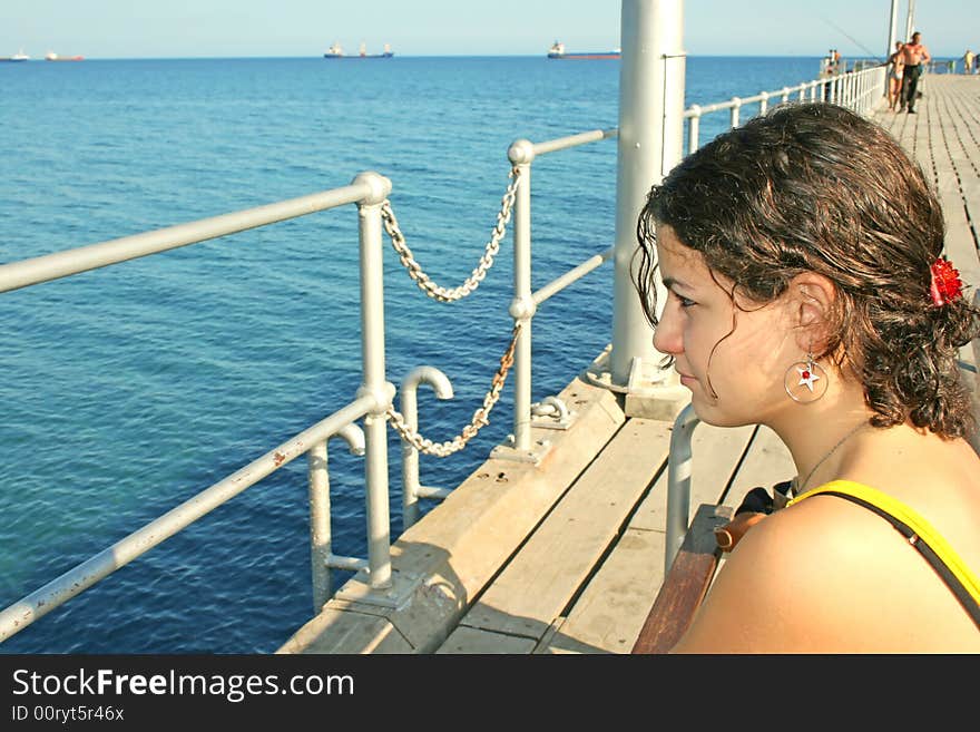 The girl on the pier at the sea. The girl on the pier at the sea.