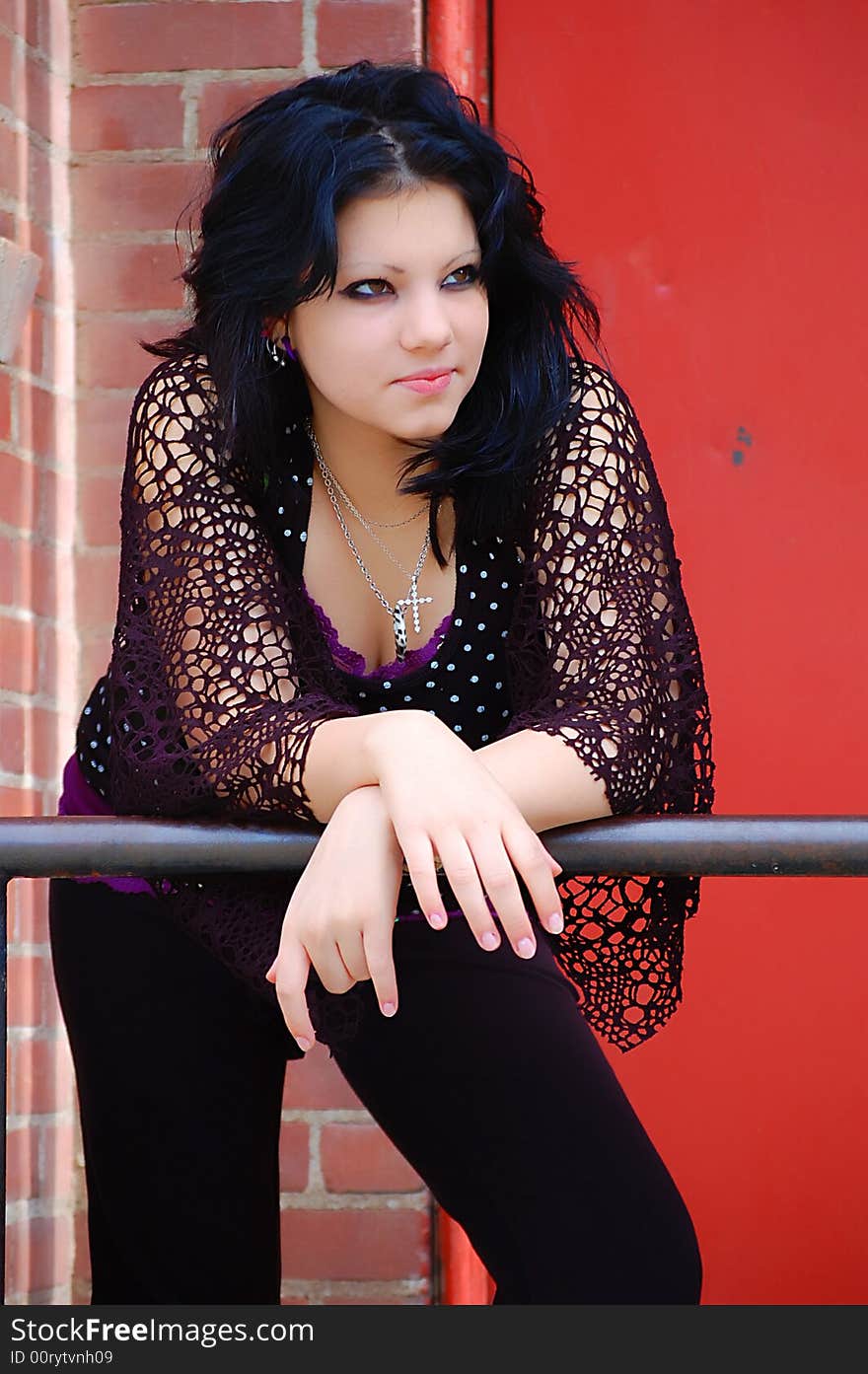 Long Black Hair Female Black Clothing standing against railing. Long Black Hair Female Black Clothing standing against railing