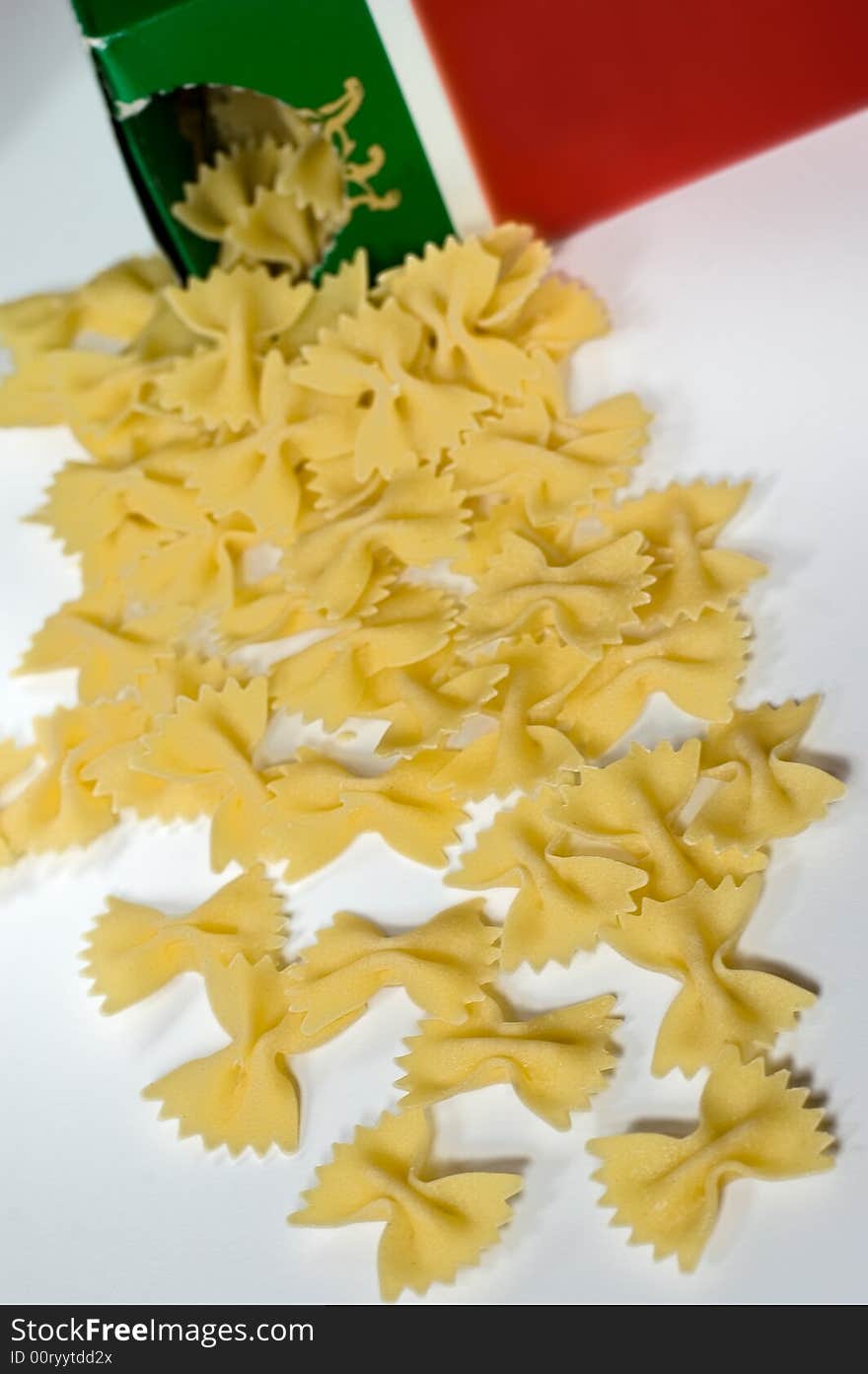 Farfalle pasta spilling out from the box on white background
Focus on the front