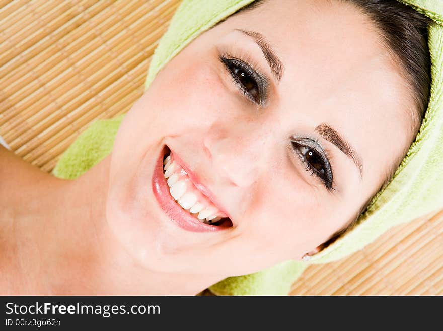 Attractive woman on Bamboomat smiling to you. Closeup on Face and collarbone. Tilted. Attractive woman on Bamboomat smiling to you. Closeup on Face and collarbone. Tilted.