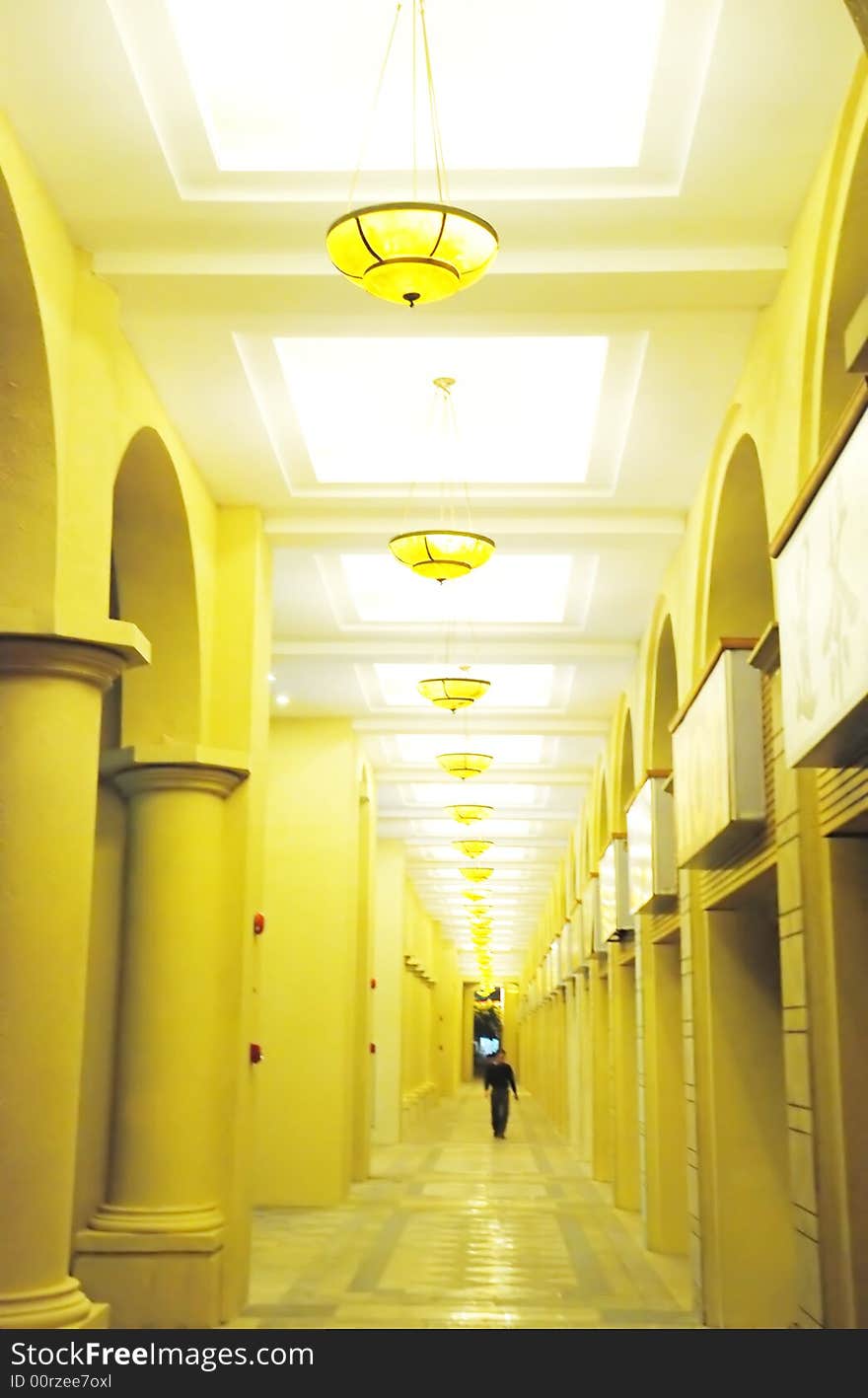 A long corridor of an apartment block , files of coloumns,pendant lamps. A long corridor of an apartment block , files of coloumns,pendant lamps