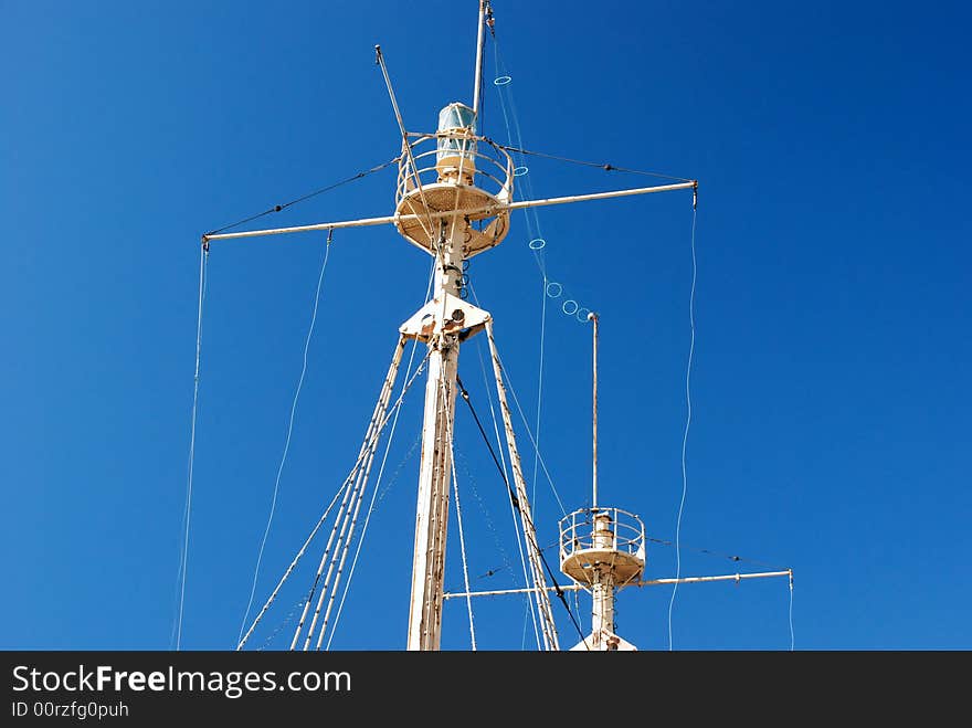 Antique boat riggings and posts against a blue sky. Antique boat riggings and posts against a blue sky