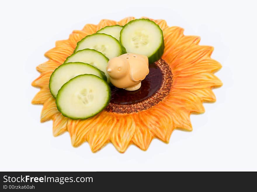 Cucumber slices and salt-cellar on a flower-shaped plate