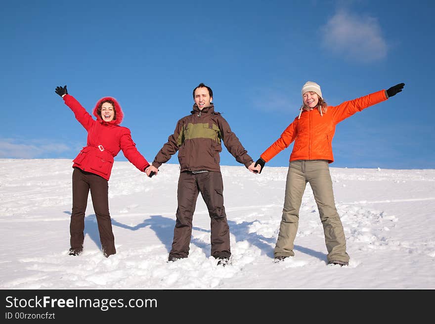 Three friends stand on snow