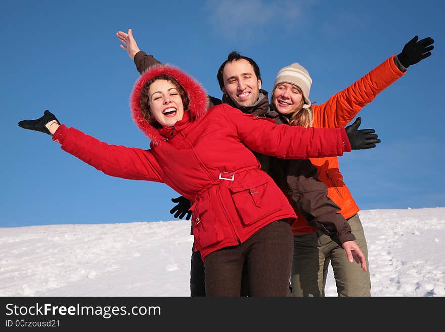 Group of friends move by hands in winter on hillside