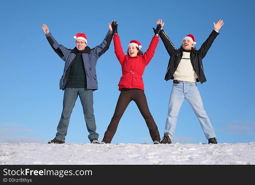 Three friends greetings on snow  in santa claus hats. Three friends greetings on snow  in santa claus hats