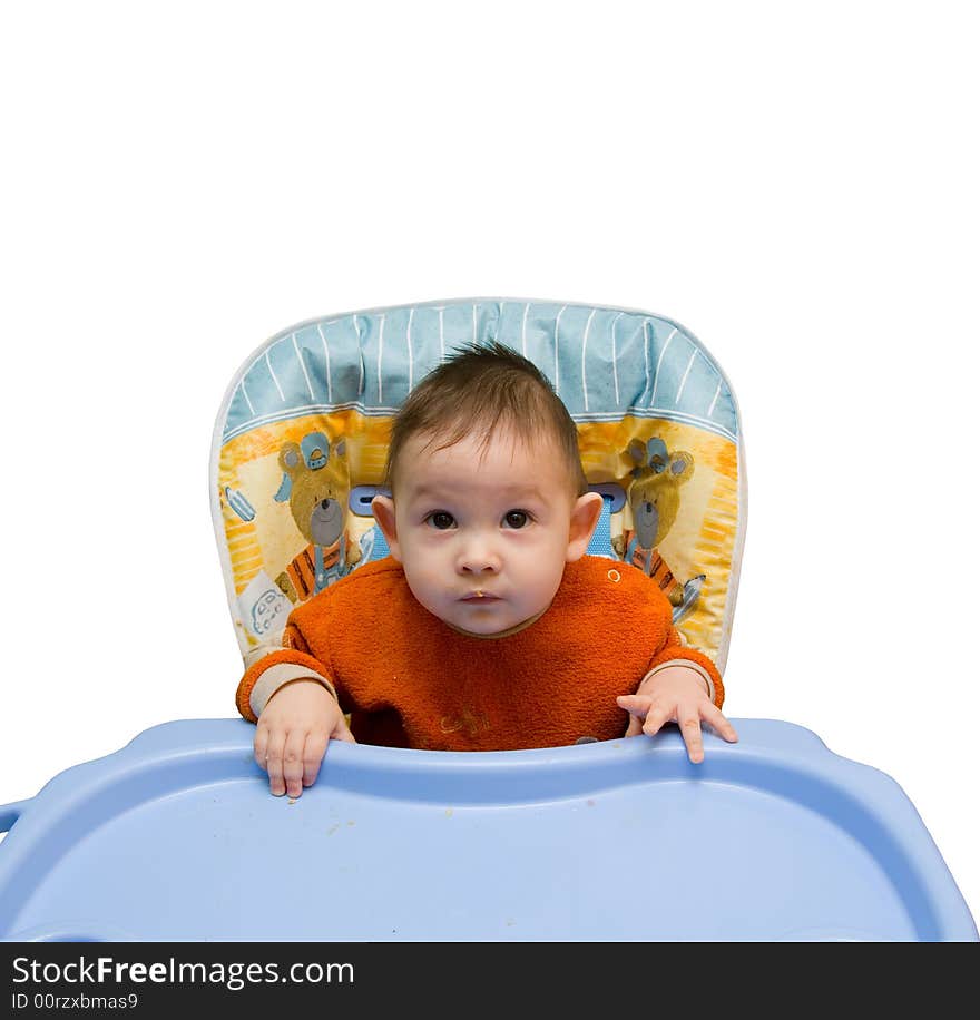 The small child sits at a children's little table on a white background. The small child sits at a children's little table on a white background