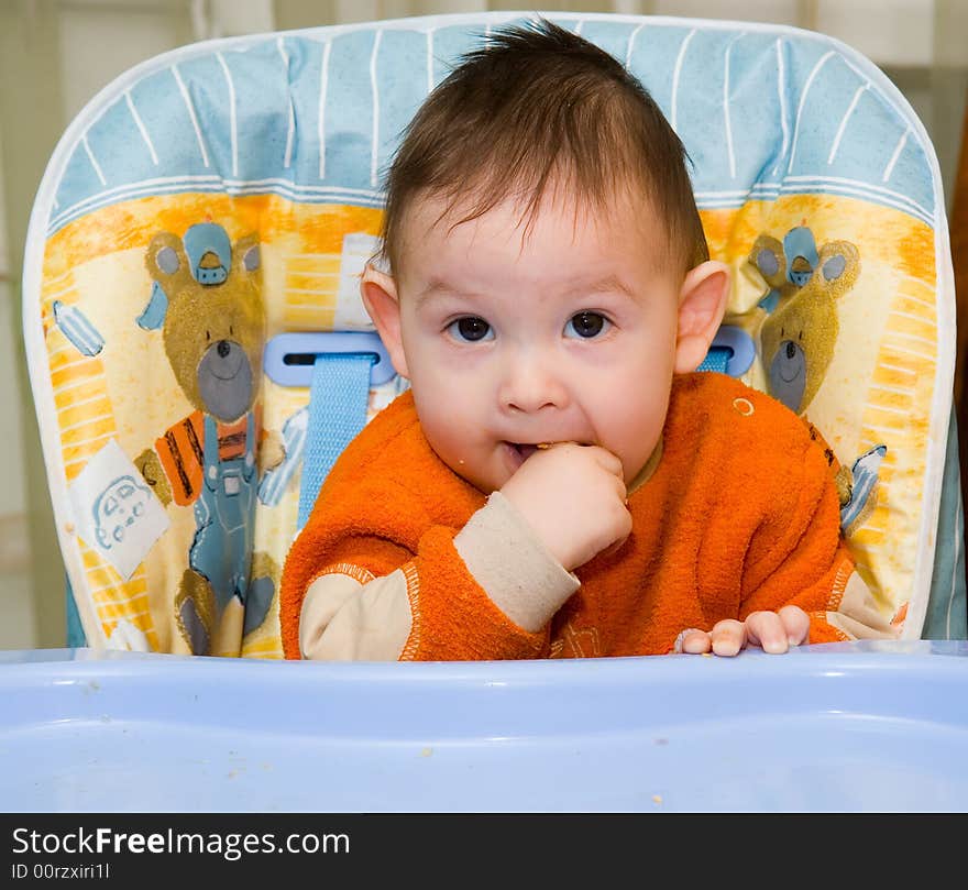 The small child sits at a children's little table. The small child sits at a children's little table