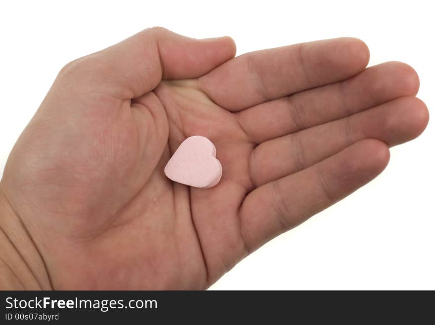 Hand with heart shaped sweet isolated on a white background