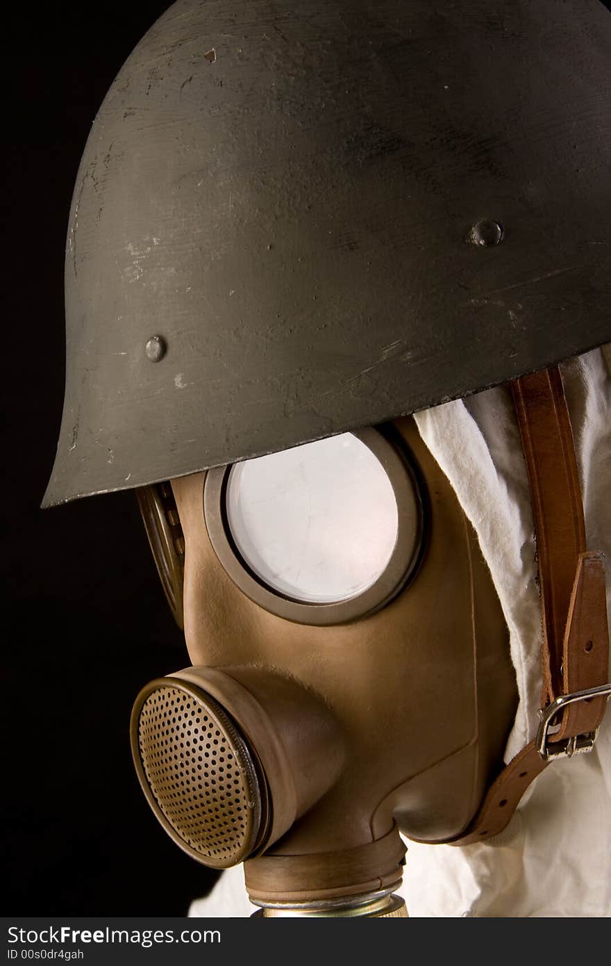 Military person in gas mask and helmet on black background