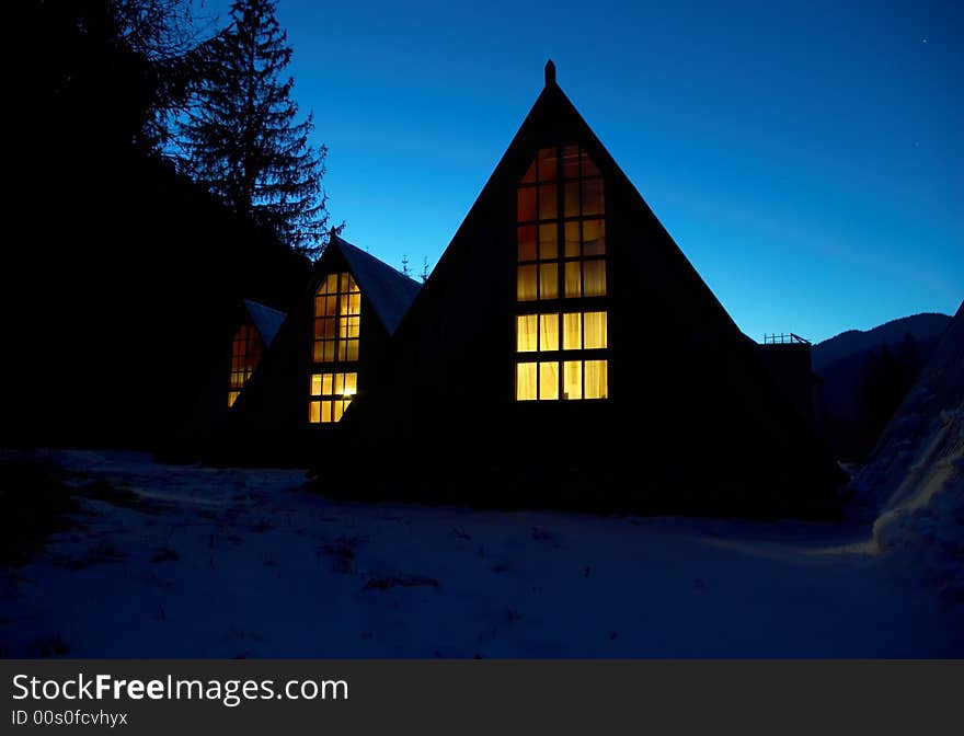 Snow-covered small houses at night in mountains. Snow-covered small houses at night in mountains