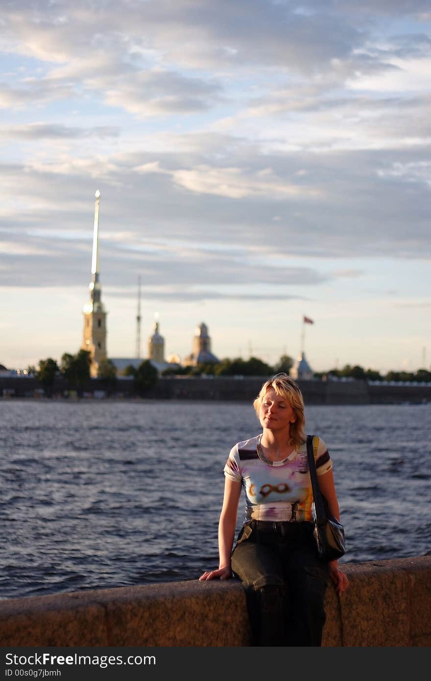 Girl sitting on canal border in Saint Petersburg