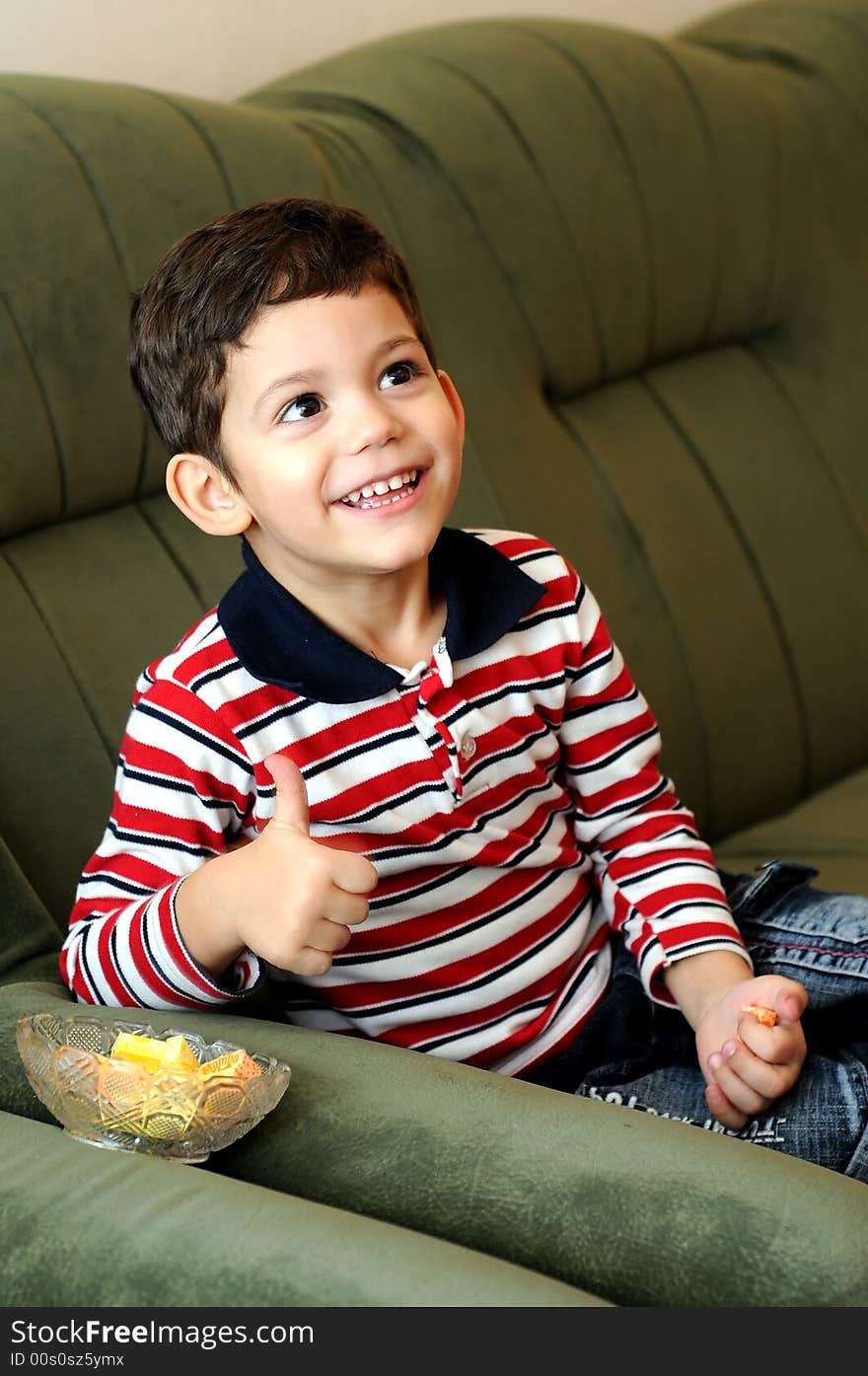 Little boy laughing sitting on sofa