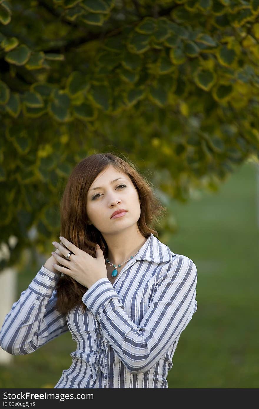 Beauty brunette in a park correct you hairstyle