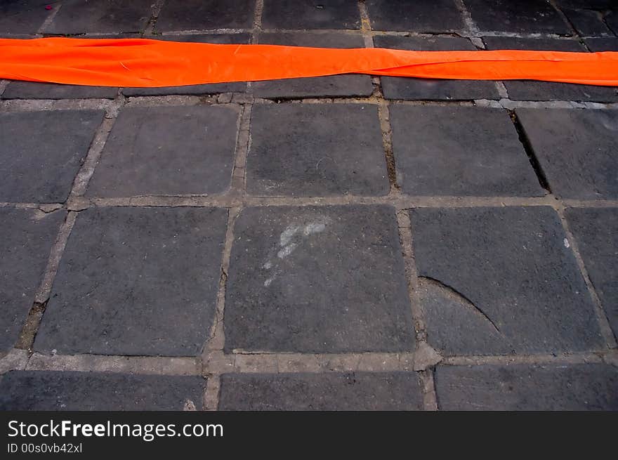 A thread of orange monks robe lying on the ground. A thread of orange monks robe lying on the ground