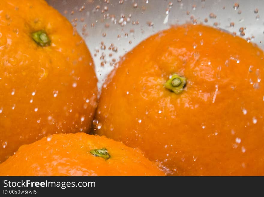 Water drops falling on three oranges. Water drops falling on three oranges