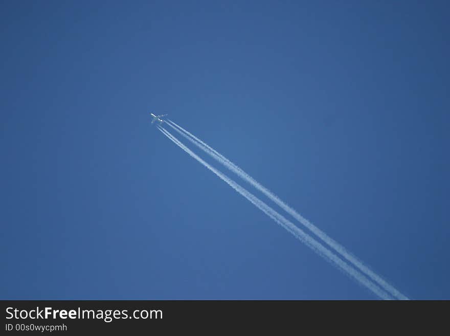 Airplane in the blue sky with condensation exhaust stripes
