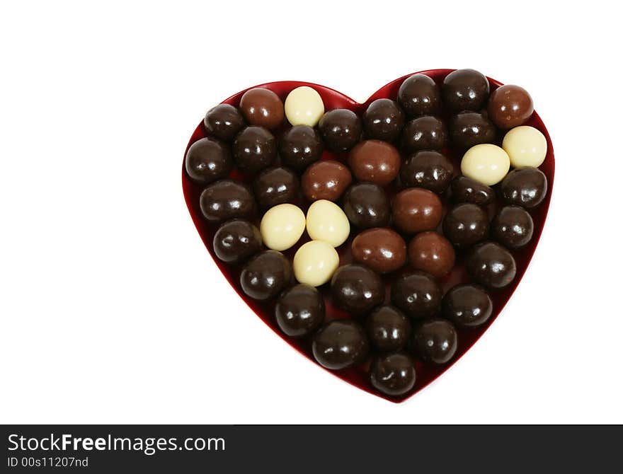 Heart and chocolate candies on white