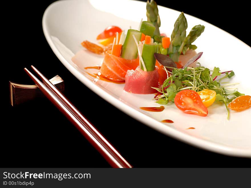 Sashimi on a white plate with chop sticks