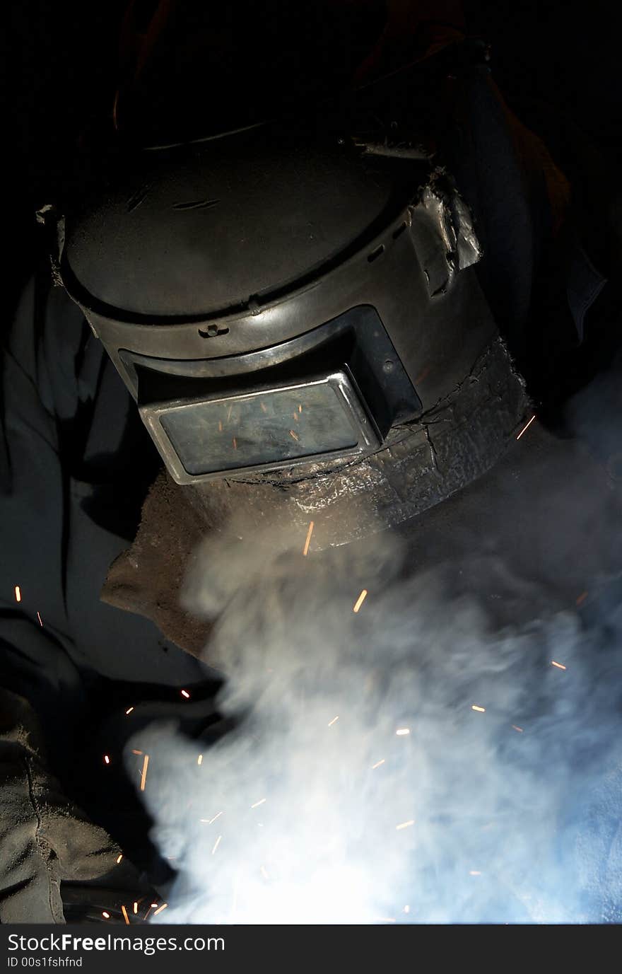 A welder working at shipyard at night. A welder working at shipyard at night