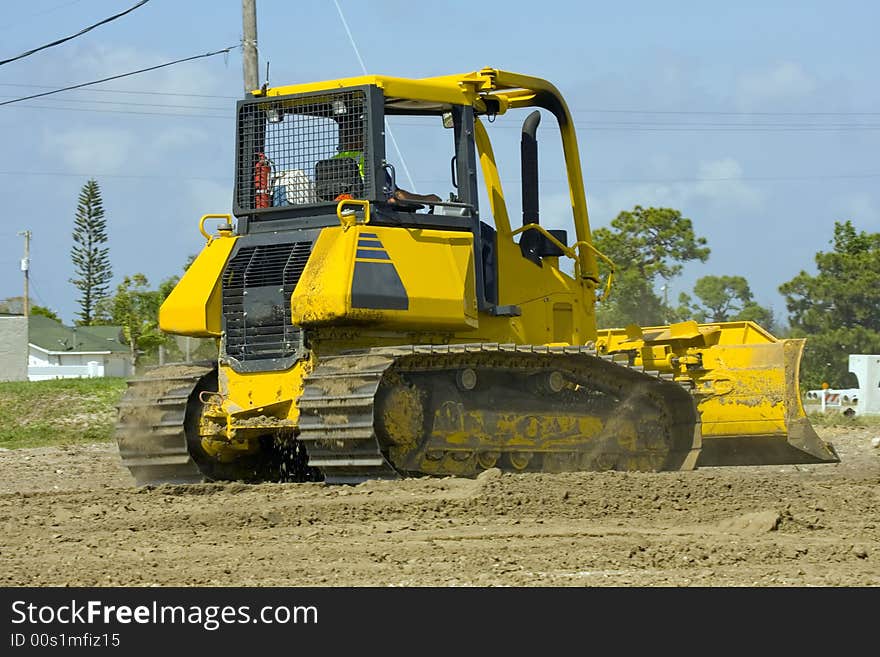 A bulldozer scraping down the job site after the heavy equipment has left. A bulldozer scraping down the job site after the heavy equipment has left