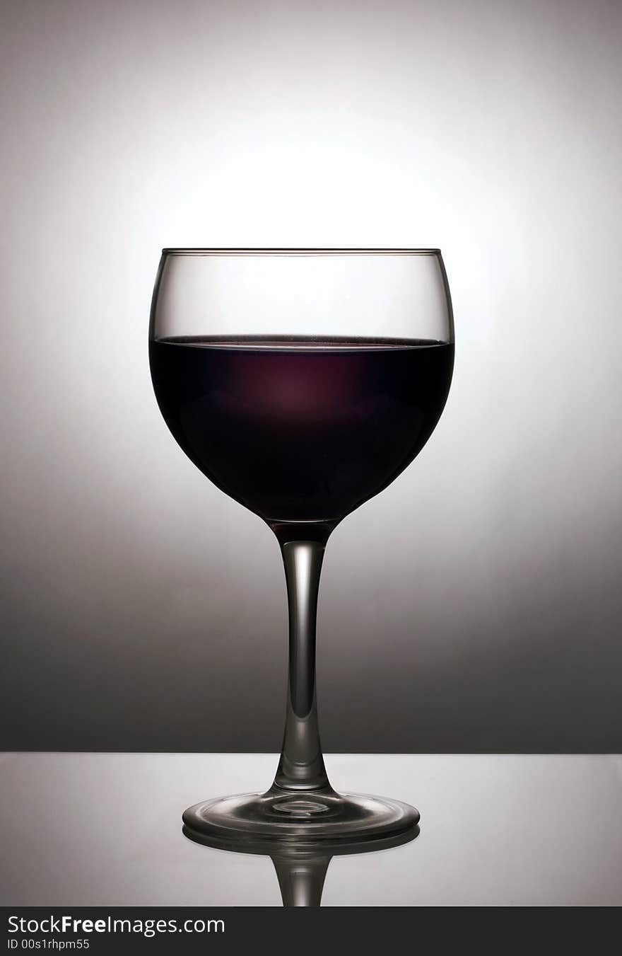 Glass of wine silhouetted against spotlight