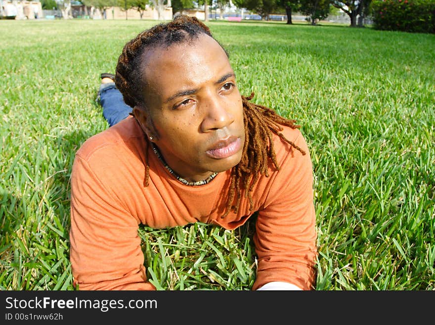 Man lying on the grass looking at something. Man lying on the grass looking at something