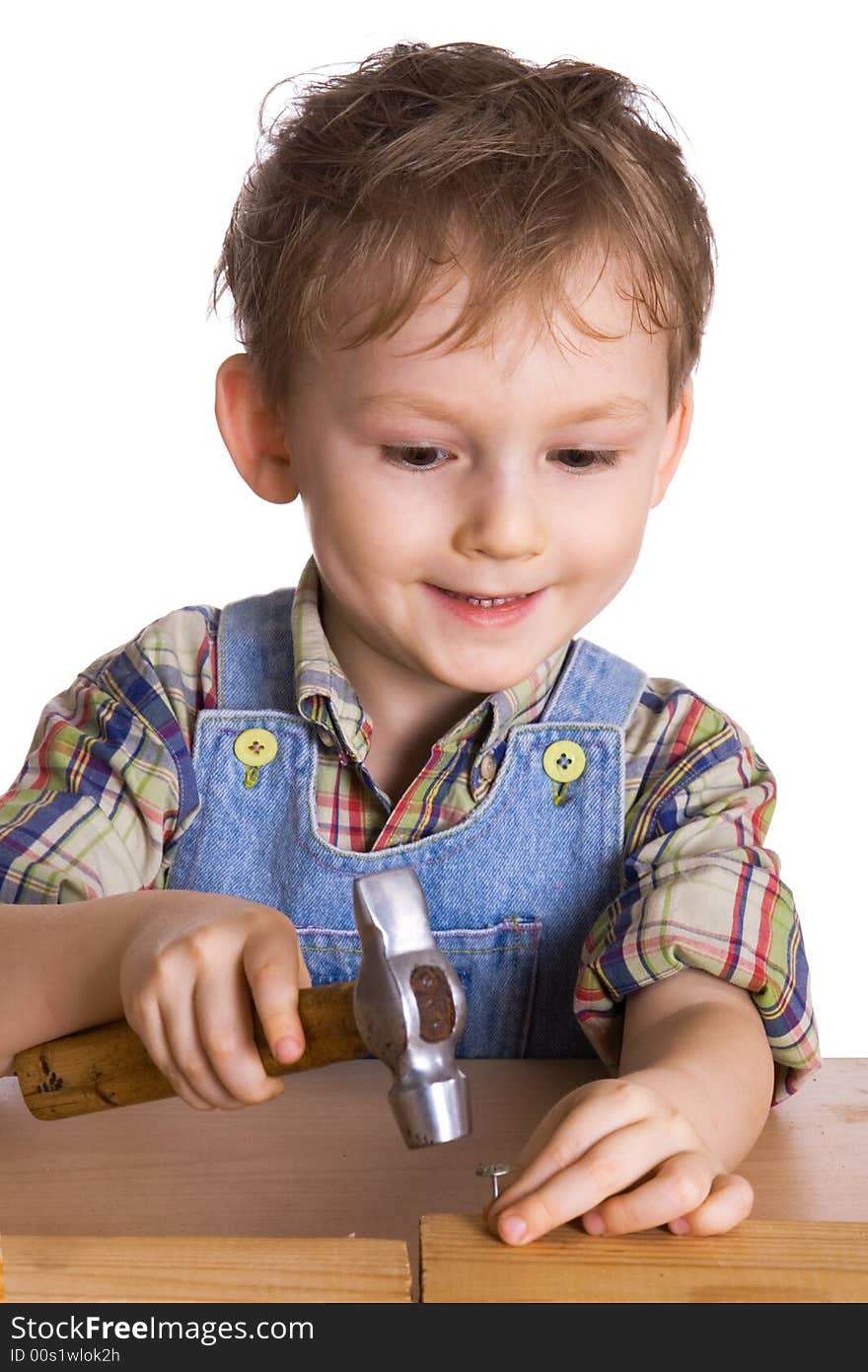 Kid hammers a hammer in nails