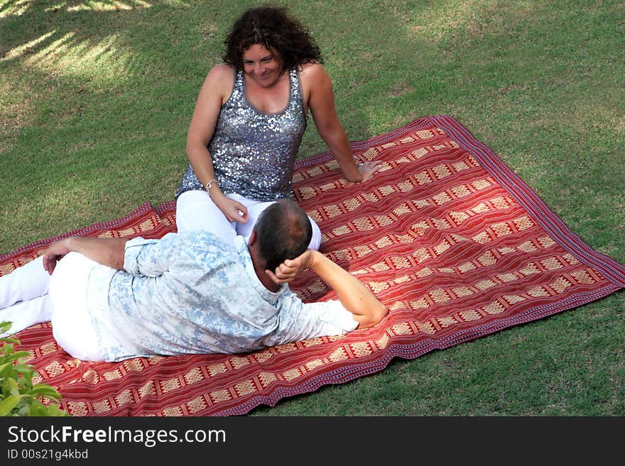 Man and woman on a rug in the park. Man and woman on a rug in the park