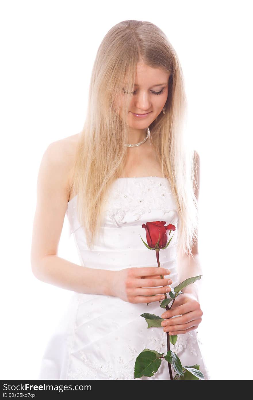 Young smiling bride look to red rose in her hands