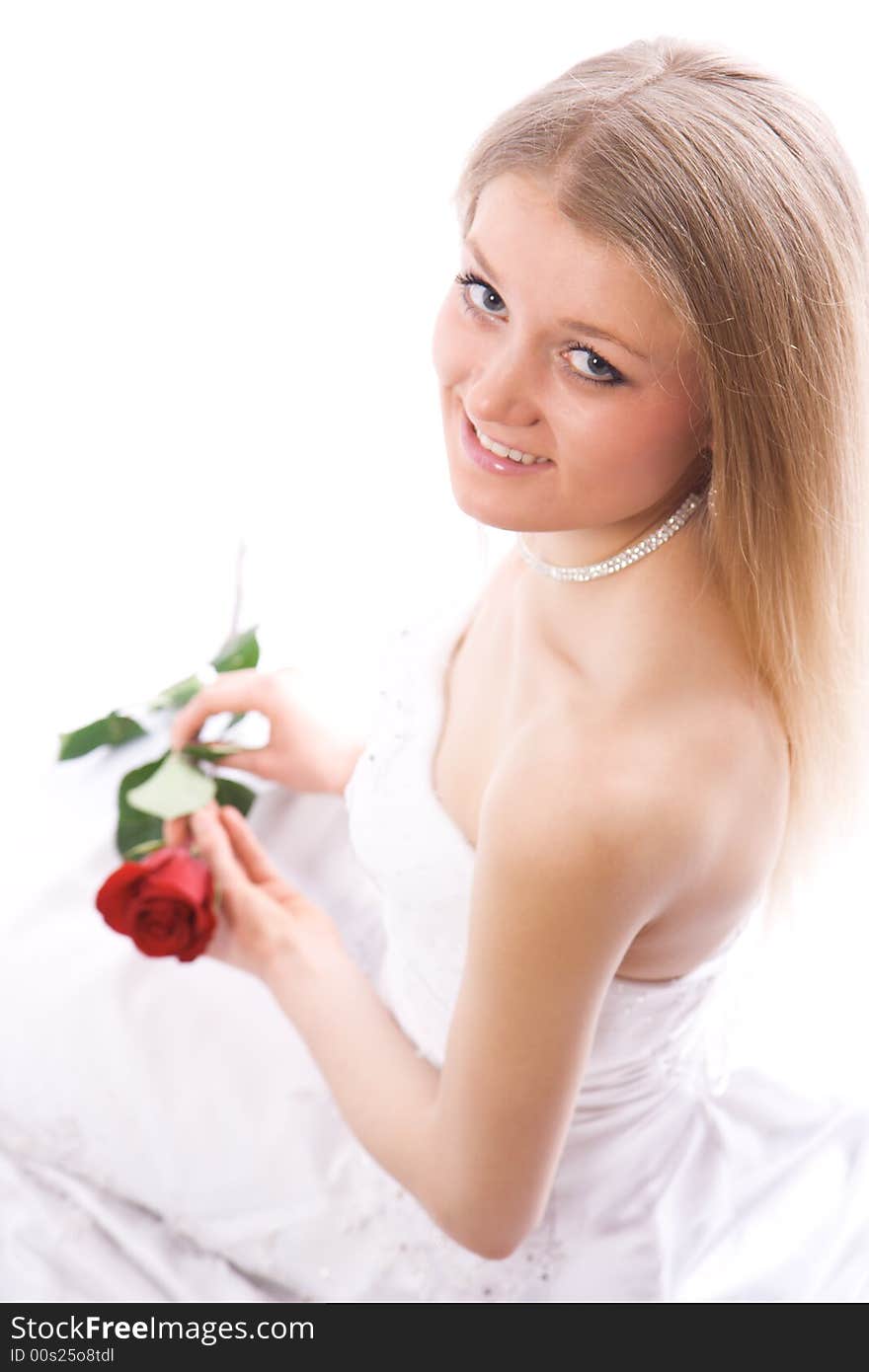 Young smiling bride with rose in hands sit and look to camera