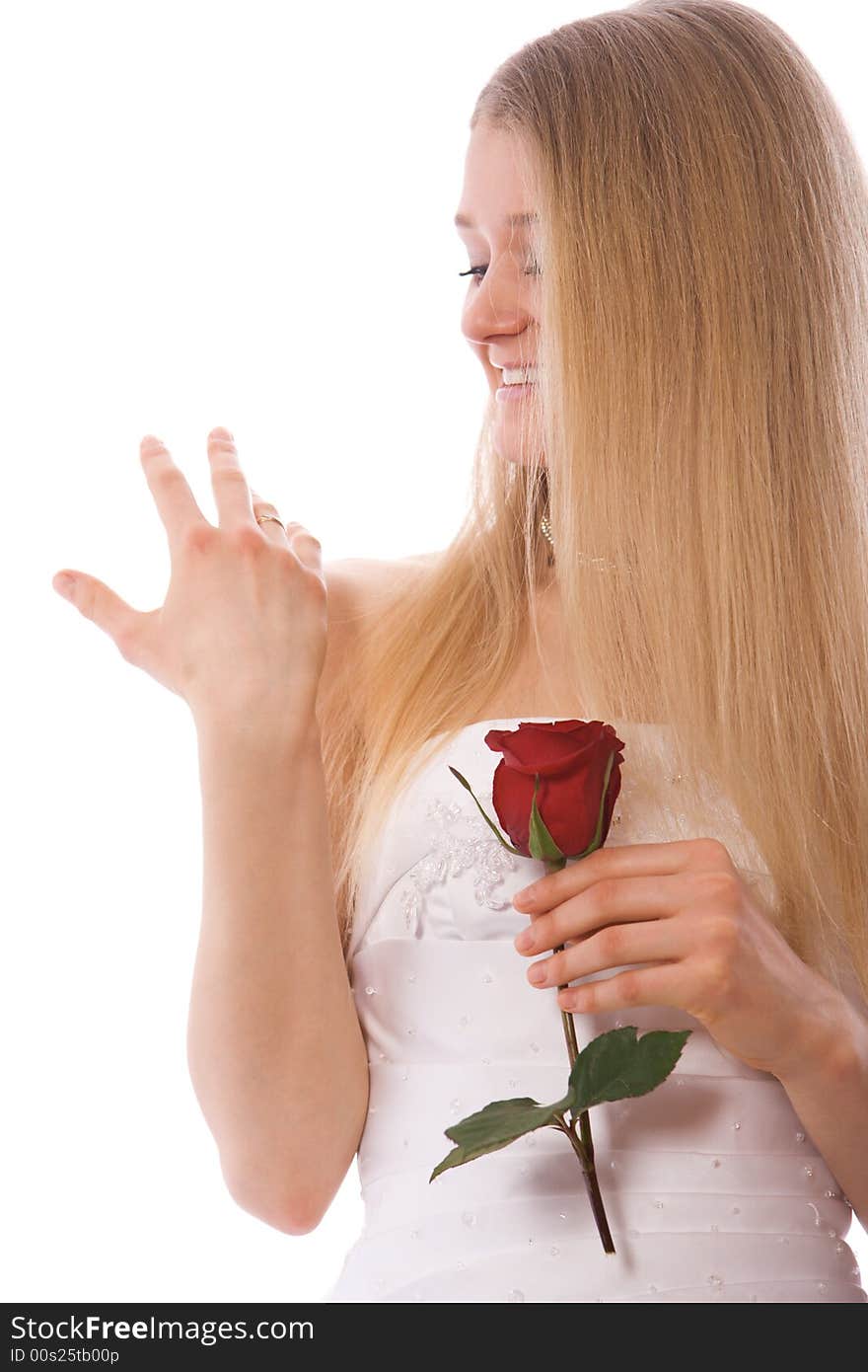 Young smiling bride with rose look to ring on hand