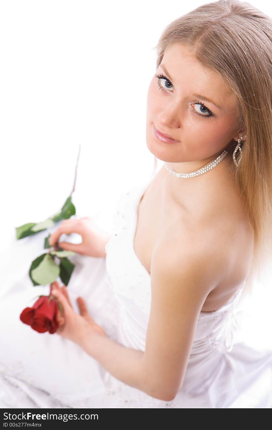 Young smiling bride with rose in hands sit and look to camera