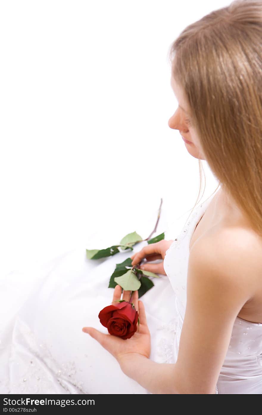 Young bride with rose in hands sit on floor