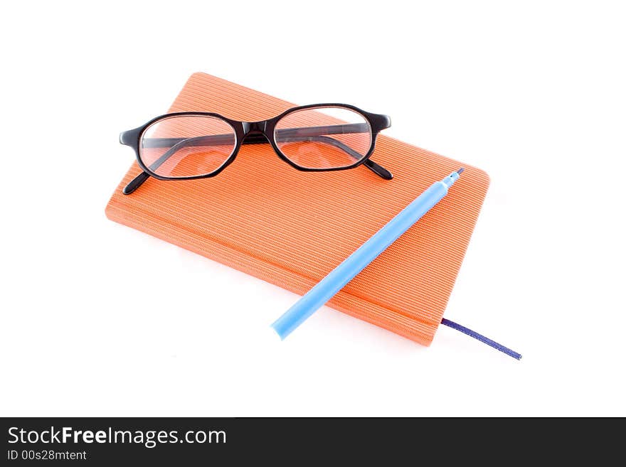 Red book, black glasses and marker