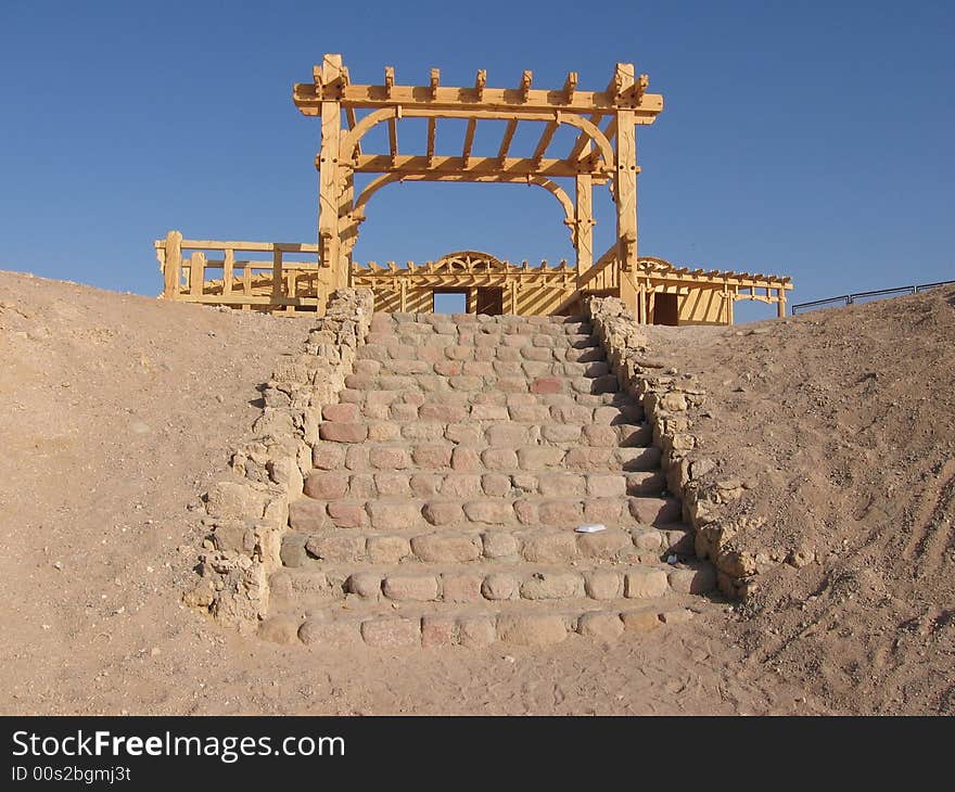 A rock stair in red sea, with a wood brown building