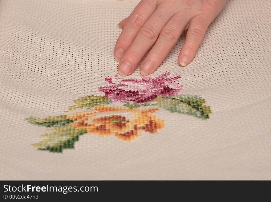 Woman embroidering a beautiful pink rose. Woman embroidering a beautiful pink rose