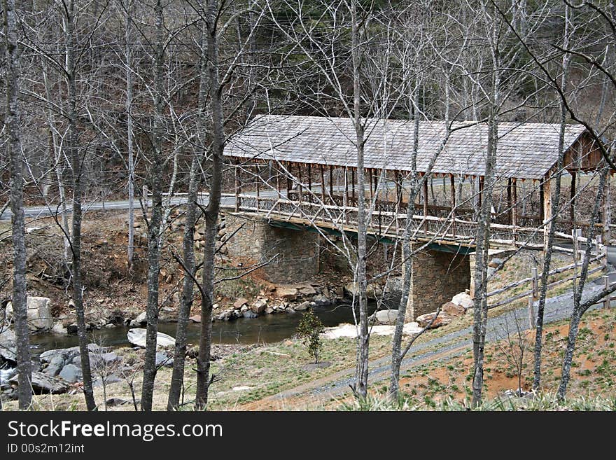 Rustic covered bridge over a river.